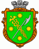Vert bordure or, a caduceus or and an axe argent saltirewise, four octagrams or in chief, in base and in fess, and overall surmounted by a mural crown argent.
